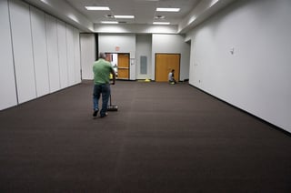 The carpet is being secured to the floor with a roller. 